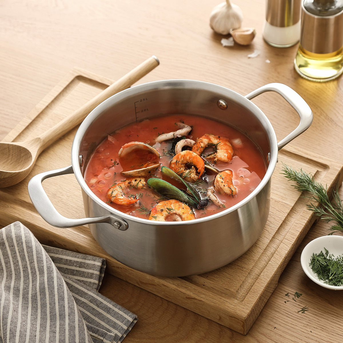 Fischsuppe mit Garnelen in einem Kochtopf aus 3-Ply Edelstahl auf einem Schneidebrett