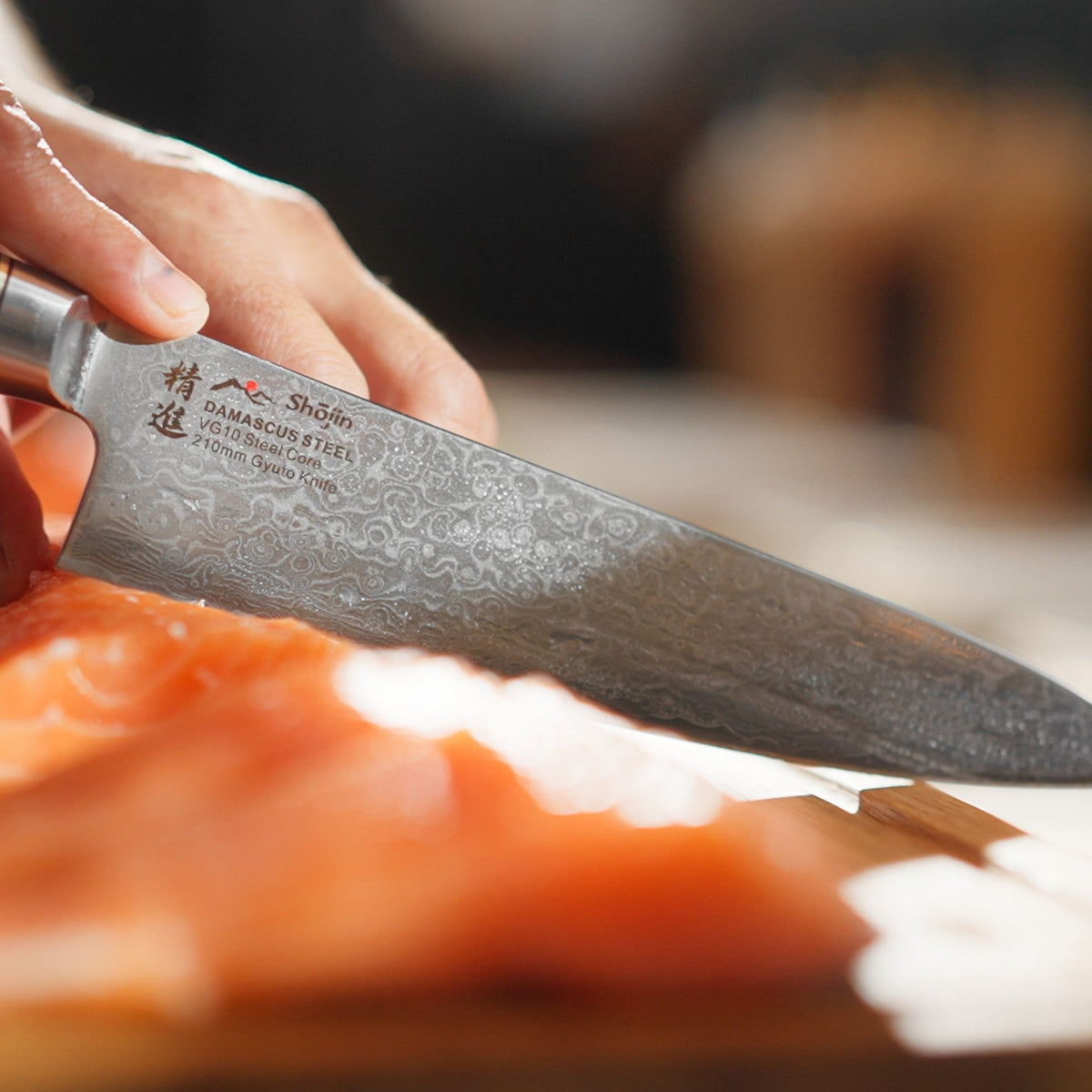 Lachs wird mit einem Shōjin Kaku Gyuto in Scheiben geschnitten, Nahaufnahme der Klinge
