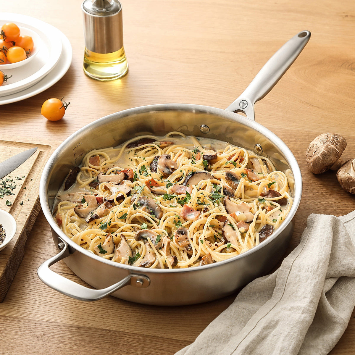 Pasta mit Pilzen in einer Sautierpfanne aus 3-Ply Edelstahl auf einem Holztisch
