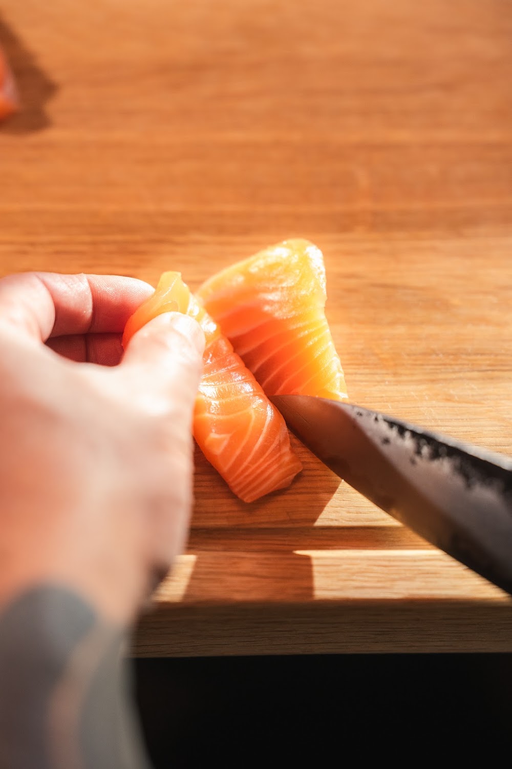 Lachs wird in der Küche des Sushi Taro geschnitten