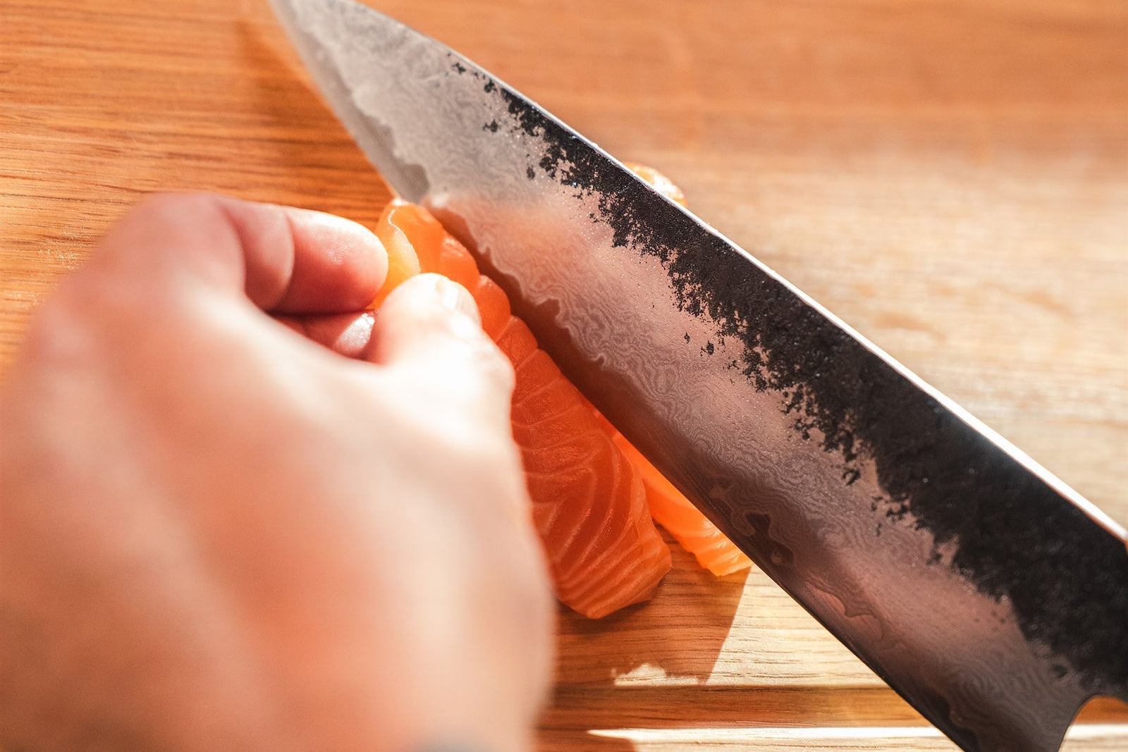 Die Klinge eines Shōjin Kashi Kochmessers schneidet Lachs in Scheiben